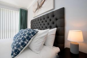 1 dormitorio con 1 cama con cabecero grande en Nautica 410 by Mountain City Investments, en Mossel Bay