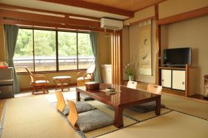 a living room with a table and chairs at Senso Yutagawa in Tsuruoka