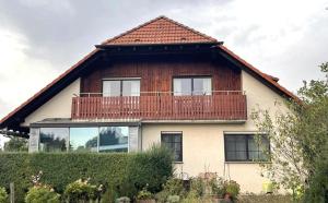 a house with a balcony on top of it at Ferienwohnung Wintersonne in Bad Mergentheim