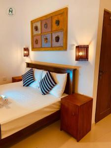 Un dormitorio con una cama con almohadas azules y blancas. en Allen Lilly Ahangama, en Ahangama