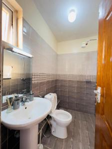 a bathroom with a white sink and a toilet at Luxe Haven in Eldoret +4 photos