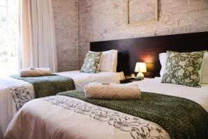 a hotel room with two beds and a window at Rooiberg View Clarens in Clarens