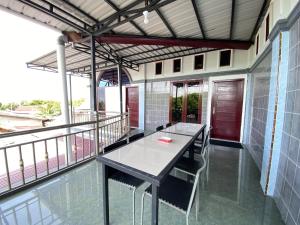 a room with a table and chairs on a balcony at De Papel Homestay in Kota Bawah Timur
