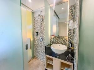 a bathroom with a sink and a shower at Kuta Beach Hotel in Kuta +49 photos