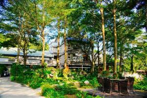 a building with a garden with benches and trees at Ming Shan Villa in Dashu