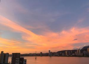einen Sonnenuntergang über einer Stadt mit einem großen Wasserkörper in der Unterkunft Bali Design River View in Bali