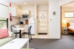 a kitchen and a living room with a couch and a table at Tranquil Getaways On Obi Maleny in Maleny