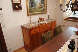 Villa Lovisa في لوفيزا: طاولة غرفة طعام مع خزانة خشبية مع الشموع عليها