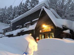 a snow covered building with a sign on it at Drifter Myoko in Myoko