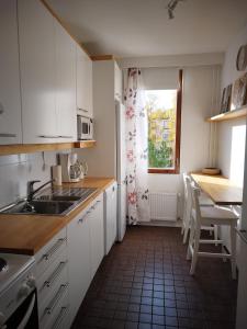 una cucina con mobili bianchi, un lavandino e una finestra di Skandinavisen taiteilijan 2 h huoneisto 2 a Lahti Altre 6 foto