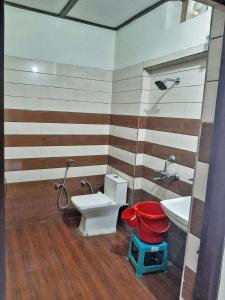 a bathroom with a toilet and a sink at Corbett Sunrise India Homestay! in Rāmnagar