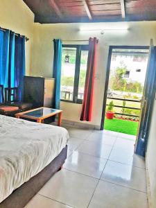 a bedroom with a bed and a living room at Corbett Sunrise India Homestay! in Rāmnagar