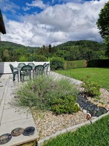a garden with a bench and a table and chairs at Chez Katy in Ban-sur-Meurthe-Clefcy