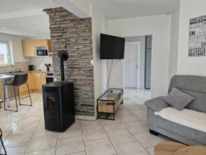 a living room with a fireplace and a couch at Chez Katy in Ban-sur-Meurthe-Clefcy
