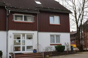 a house with a brown and white at FeWo Kruse am Wurmberg in Braunlage +5 photos