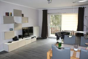 a living room with a television and a table and chairs at FeWo Kruse am Wurmberg in Braunlage