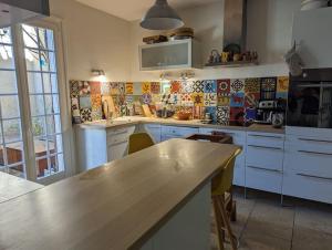 una cucina con mobili bianchi e un piano di lavoro in legno di Maison cosy Avignon ad Avignone