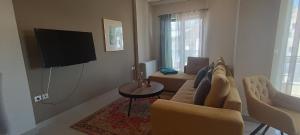 ein Wohnzimmer mit Sofa und Fernseher in der Unterkunft EleVSis -1-2 in Eleusis