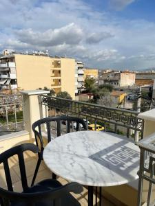 Ein Tisch und Stühle auf einem Balkon mit Aussicht in der Unterkunft EleVSis -1-2 in Eleusis