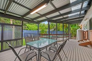 KarraganbahにあるFamily Retreatのデッキにテーブルと椅子が置かれたパティオ