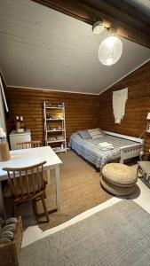 a bedroom with a bed and a table and chairs at Hirsimökki,Meri,Sauna,Terassi in Kustavi