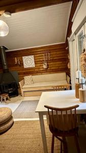 a living room with a bench and a table and chairs at Hirsimökki,Meri,Sauna,Terassi in Kustavi
