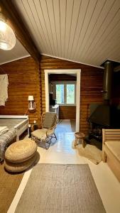 a living room with a room with a fireplace and a stove at Hirsimökki,Meri,Sauna,Terassi in Kustavi +6 photos