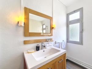 a bathroom with a white sink and a mirror at Tourette - appartement proche du centre-ville - Saint-Denis in Saint-Denis