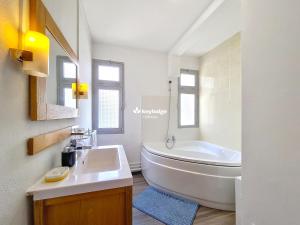 a bathroom with a white tub and a sink at Tourette - appartement proche du centre-ville - Saint-Denis in Saint-Denis
