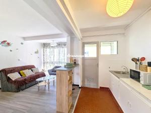 a kitchen and living room with a couch and a table at Tourette - appartement proche du centre-ville - Saint-Denis in Saint-Denis +7 photos