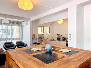 a living room with a wooden table and a kitchen at Tourette - appartement proche du centre-ville - Saint-Denis in Saint-Denis