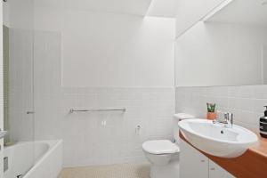 a white bathroom with a sink and a toilet at Avoca Beach Living in Avoca Beach
