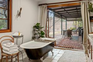 ein Badezimmer mit einer Badewanne und einer Terrasse in der Unterkunft Seppeltsfield Vineyard Cottage Luxury Romantic Getaway in Seppeltsfield