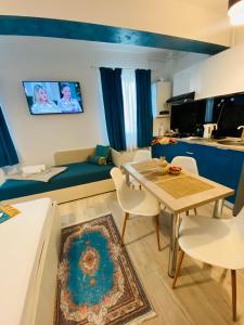 ein Wohnzimmer mit einer Couch und einem Tisch und Stühlen in der Unterkunft Studio Beatrice in Eforie Nord