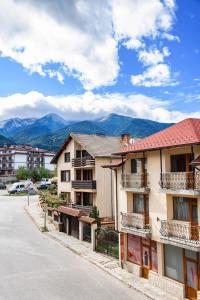 an empty street with buildings and mountains in the background at Bansko Ski Apartment in Bansko