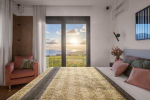 Un dormitorio con una cama y una silla y una ventana. en Villa Adler Nature&Relax, en Scopello