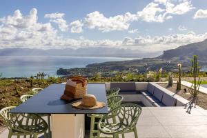 a table and chairs with a view of the ocean at Villa Adler Nature&Relax in Scopello