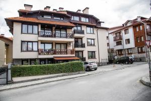 an apartment building with a car parked in front of it at Bansko Ski Apartment in Bansko