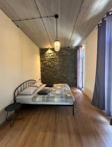 a bedroom with a bed and a brick wall at Alpine Escape Kazbegi in Kazbegi