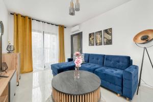 a living room with a blue couch and a table at Lux Traugutta Apartment with Air Conditioning and Parking by Noclegi Renters in Wrocław