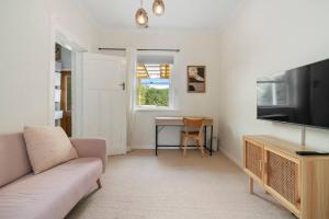 a living room with a couch and a table at New Town Bungalow - A Leafy Family Haven in New Town