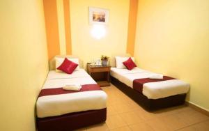 une chambre d'hôtel avec deux lits avec des oreillers rouges dans l'établissement Sun Inns Jalan Kuching, à Kuala Lumpur