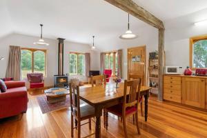 a living room with a wooden table and a couch at Wine Loft - Cosy Country Retreat with Ocean Views in Kettering