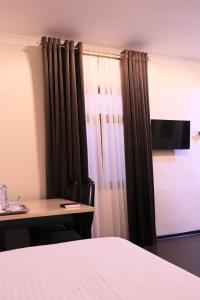 a room with a bed and a table and a curtain at Al Bukhari Boutique Hotel in Bukhara