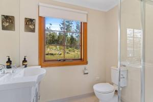 a bathroom with a sink and a toilet and a window at Country-style Stunner - Bushland Peace & Privacy in Margate +14 photos