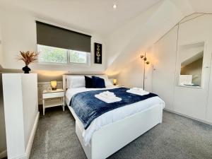 a white bedroom with a large bed and a mirror at Superb Duplex in North London with reserved parking in The Hyde