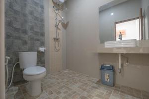a bathroom with a toilet and a sink and a mirror at Midep Home Stay in Ubud