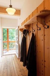 a hallway with wooden walls and wooden flooring and black jackets at Altaussee Retreat Apartment - Your Austrian Home in Altaussee
