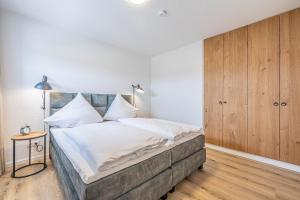 ein Schlafzimmer mit einem großen Bett mit weißer Bettwäsche in der Unterkunft Ferienwohnung Wiking-Koje 5 Schleswig in Schleswig