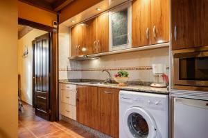 a kitchen with a washing machine and a sink at Apto Naranja - Casa el gaitero in Susacasa